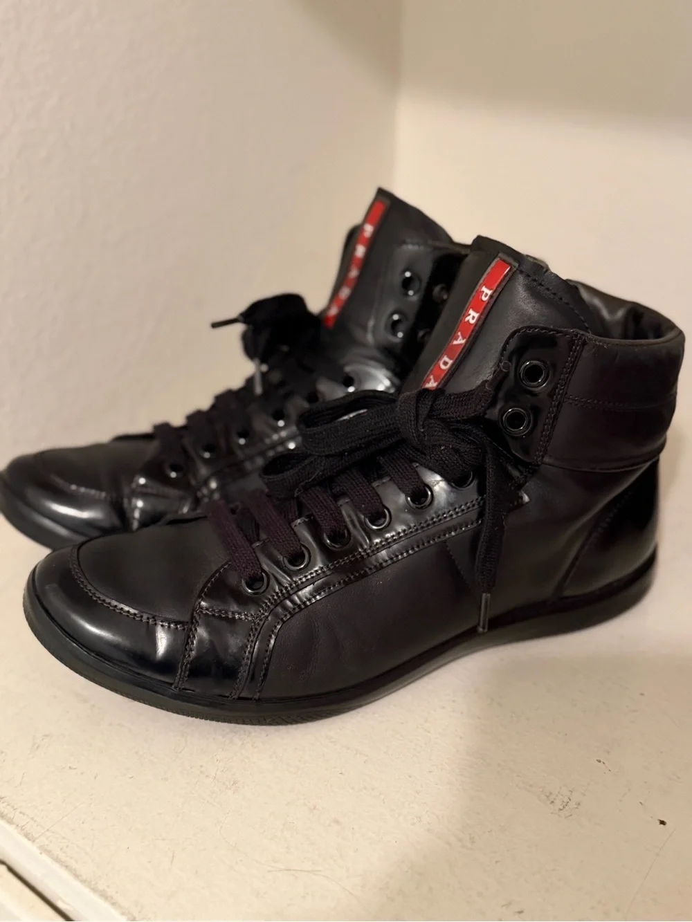 Authentic Prada Black High-Top Leather Sneakers with Red Logo